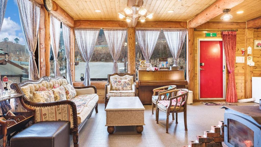 a living room with a couch and chairs and a bed at Muju Moonriver Pension in Wŏnsamgŏri