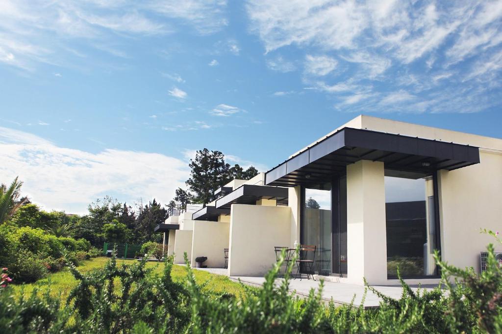 a white house with a black roof at Seogwipo Jan-Jan Pension in Seogwipo