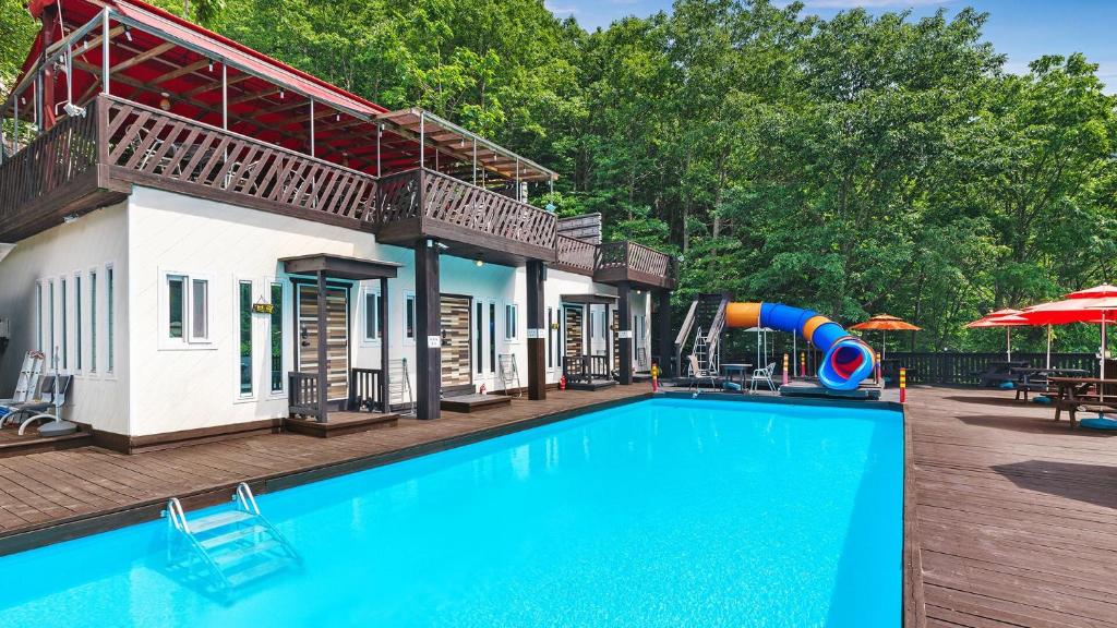 a swimming pool with a slide next to a house at Ulsan Lime House in Ulsan