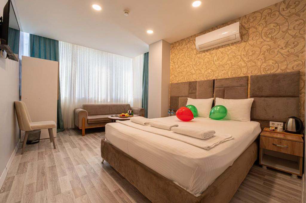 ein Schlafzimmer mit einem großen Bett und roten und grünen Kissen in der Unterkunft Casa Nova Hotel in Istanbul
