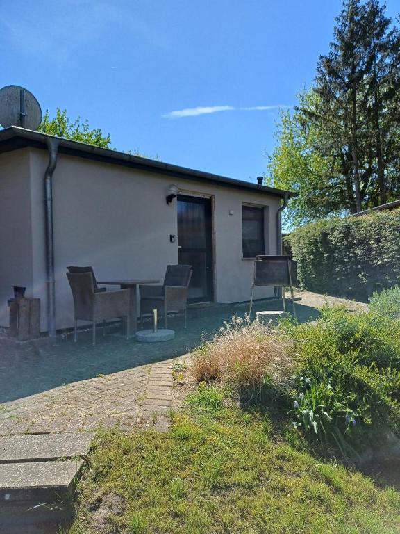 a house with chairs and a table in a yard at Gemütliches Häuschen am Fleesensee in Göhren-Lebbin