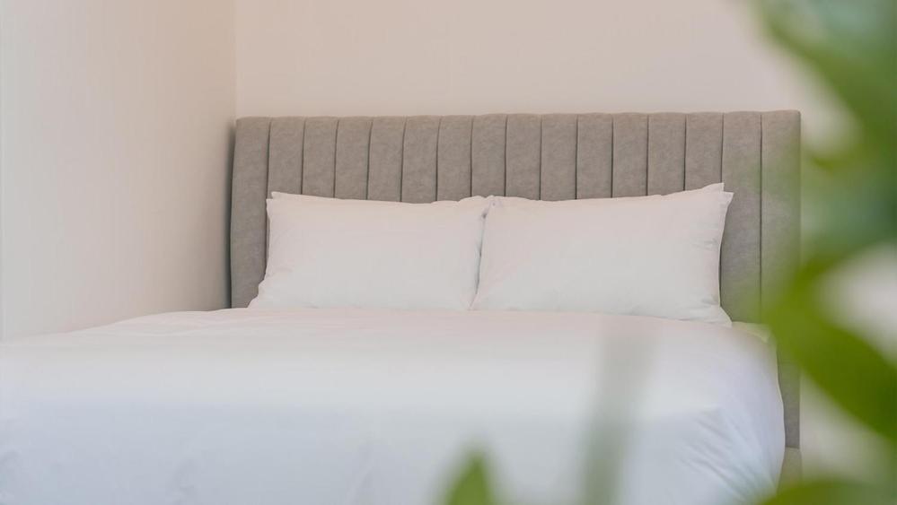 a bed with white sheets and pillows in a room at Gapyeong Zav Pool Villa in Gapyeong