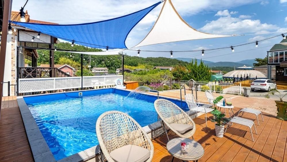 a swimming pool with chairs and a table at Gyeongju Areum Maru in Gyeongju
