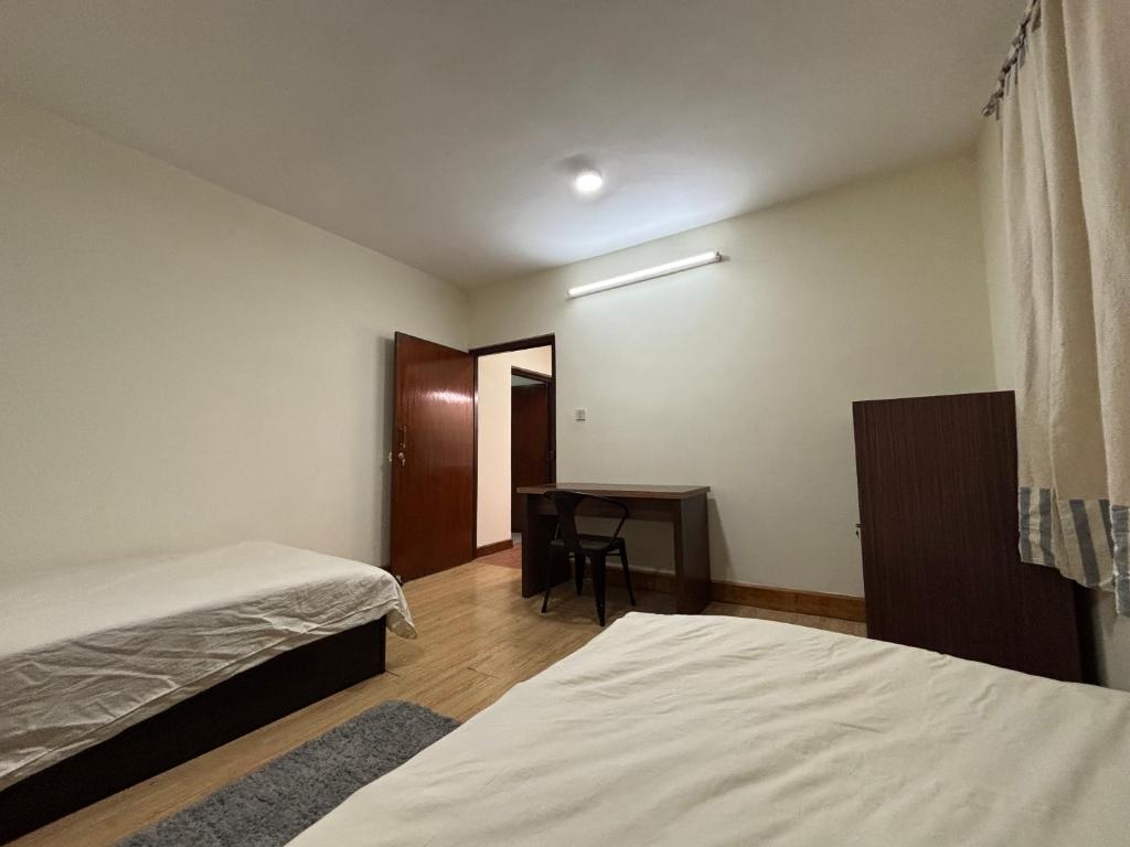 a room with two beds and a desk in it at L&S apartment in Kathmandu