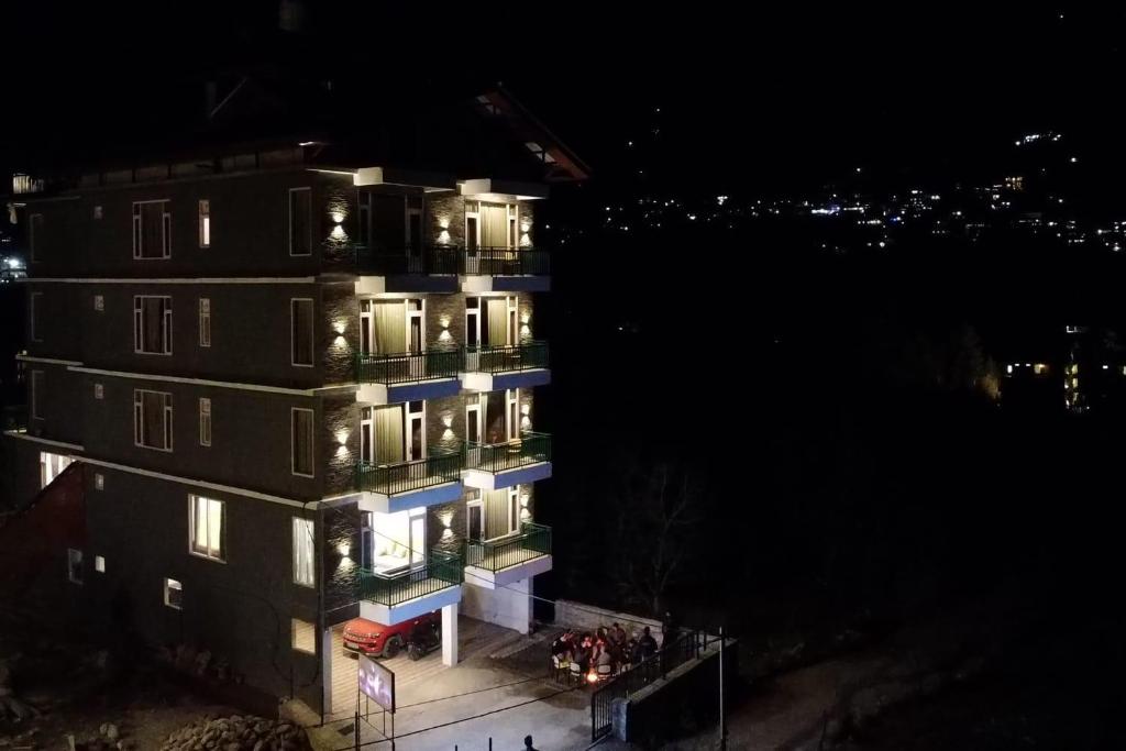 a tall building with lights on it at night at The Trippy Tribe Manali in Manāli
