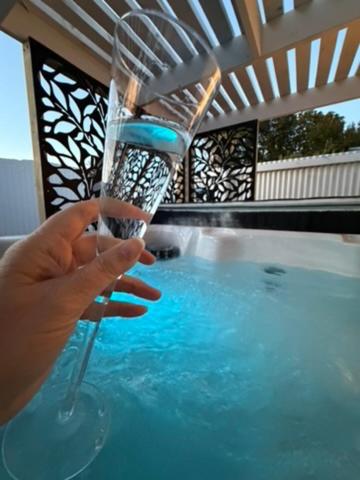 a person holding a glass of water in a swimming pool at The Nook in Greytown