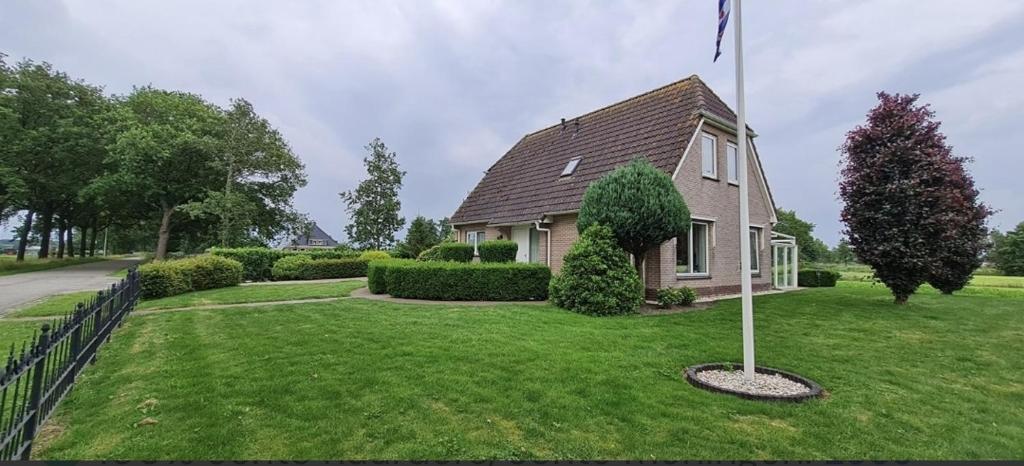 a house with a flag pole in the yard at Romsicht in Siegerswoude