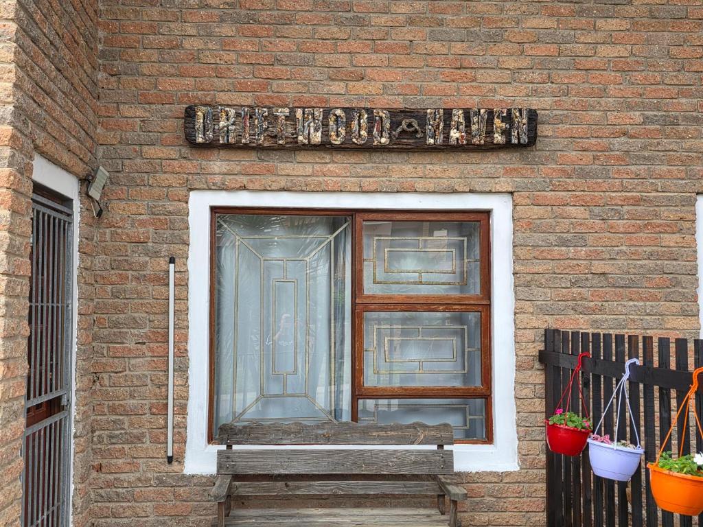 a window on a brick building with a door at Driftwood Haven in Mossel Bay