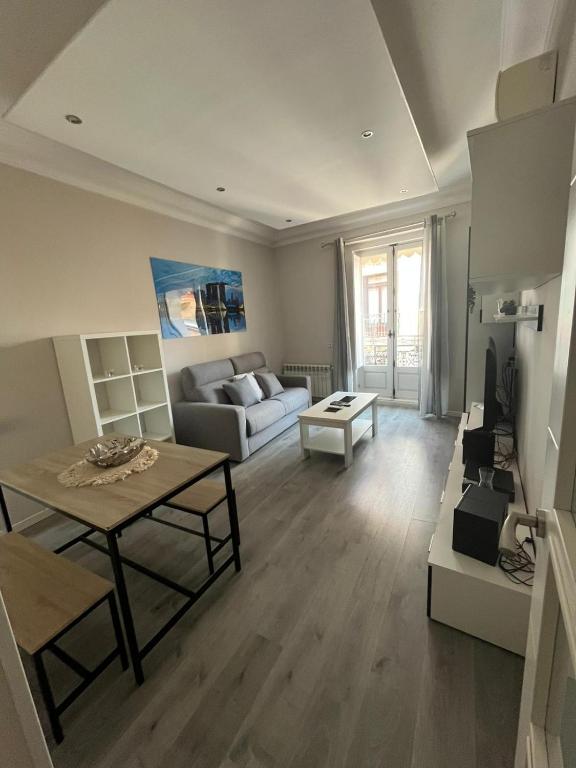 a living room with a couch and a table at Malasaña & Plaza España in Madrid