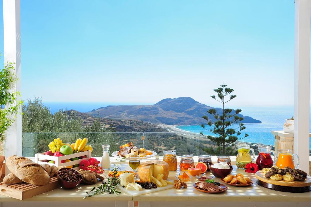 a table full of food with a view of the ocean at Stefanos Village Hotel in Plakias
