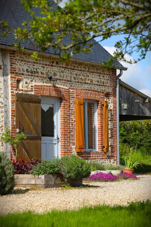 a brick house with an orange window and a door at Maison Mayjune Cottage in Irai