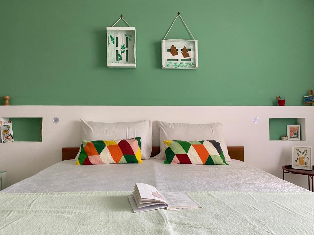 a bed with two pillows and a book on it at A casa di Nonna Maria in Marsala