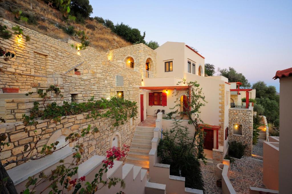 a building with stairs and a stone wall at Stefanos Village Hotel in Plakias