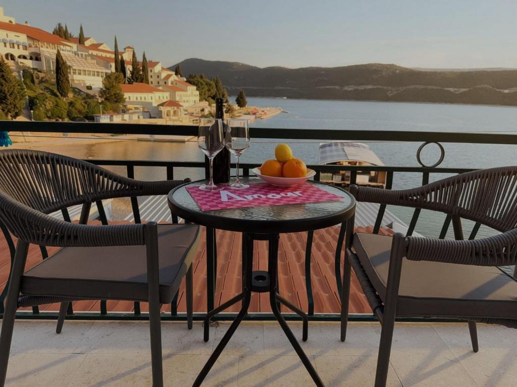 a table with a bowl of fruit on a balcony at Solmare Neum Apartmani in Neum