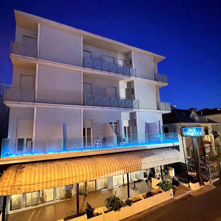 a large white building with an awning at Due Gemelle in Rimini