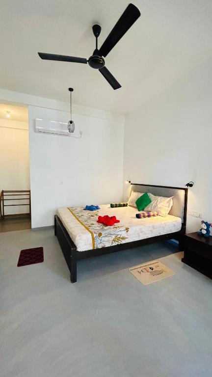 a bedroom with a bed with a ceiling fan at Saffron Swell Villa in Arugam Bay