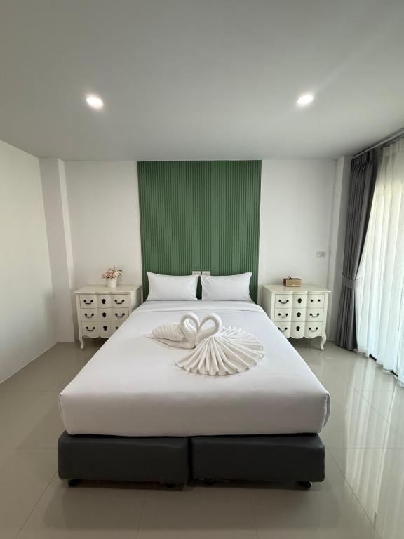 a bedroom with a large white bed with a heart on it at I am Daily Mansion in Ban Phan Sadet Nai