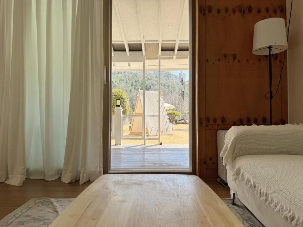 a bedroom with a sliding glass door to a patio at Gapyeong Sol Stay Spa Pension in Gapyeong