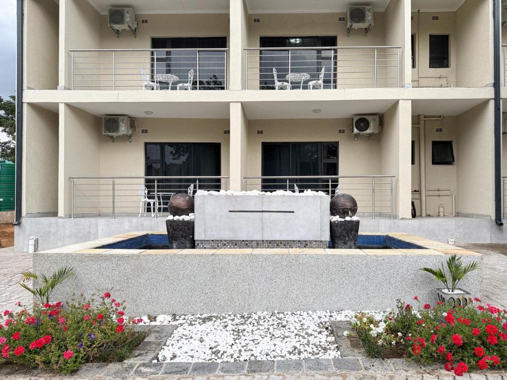 a large white building with flowers in front of it at Mevis Boutique Hotel in Bulawayo