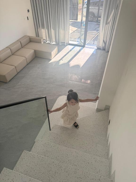 a little girl walking down the stairs in a living room at Ideal for your vacation! in Buôn Dhă Prŏng