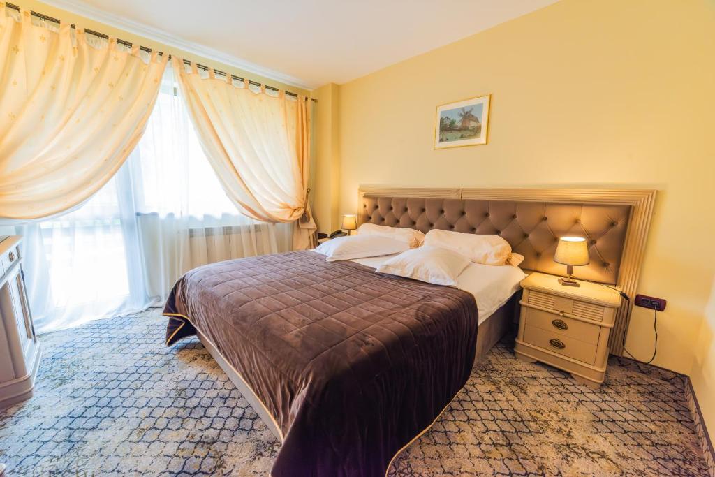 a bedroom with a large bed and a window at Bucium Motel & SPA in Iaşi
