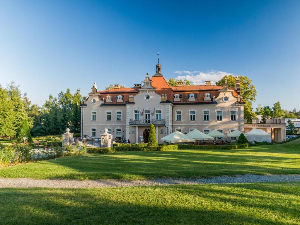 a large house on a grassy field at Hotel Zámek Berchtold in Kunice