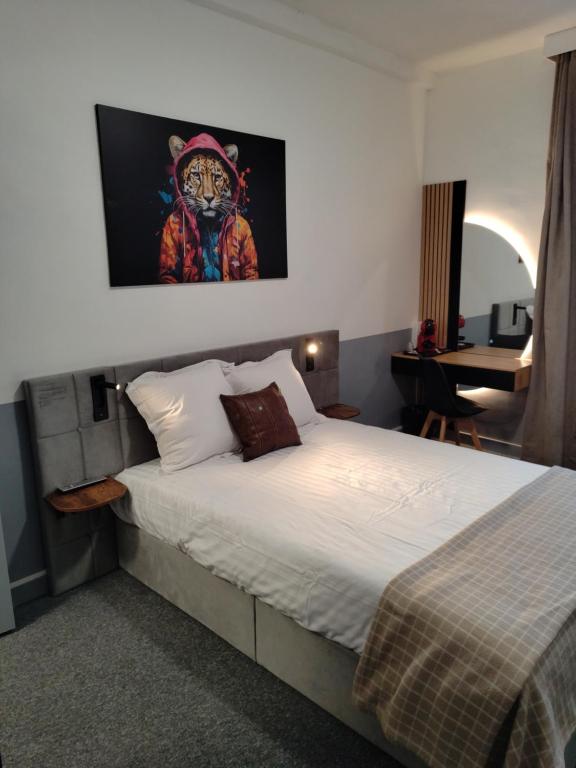 a bedroom with a bed with a painting on the wall at Hôtel Saint Daniel in Nantes