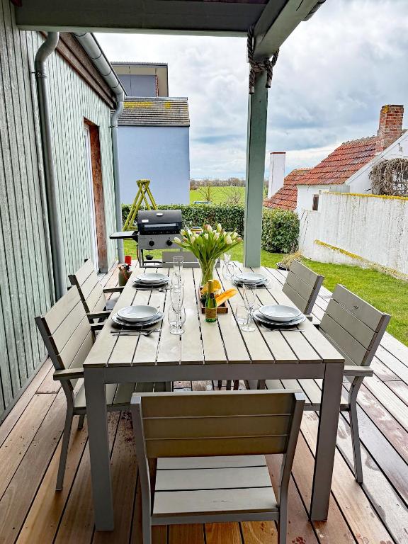 a wooden table with chairs on a wooden deck at Haus Charlotte mit Meerblick in Fehmarn