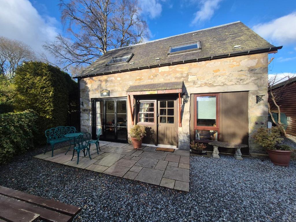 a stone house with a patio in front of it at The Old Coach House in Pitlochry