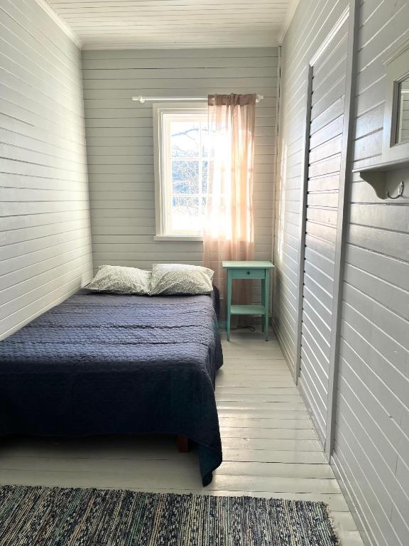 a small bedroom with a bed and a window at Vuohensaari, Rantatalo 4 in Salo