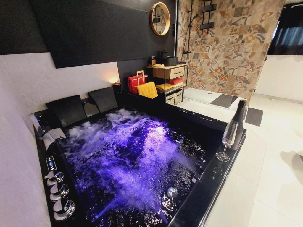 eine Badewanne mit lila Boden in einem Zimmer in der Unterkunft Le sandron in Marchin