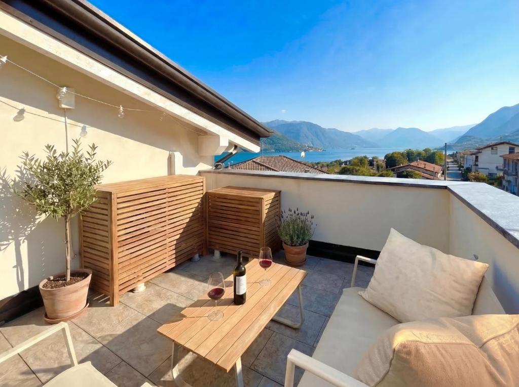 a balcony with a wooden table on a roof at PENTHOUSE ISEO LAKE VIEW - Free Wi-Fi and Private Parking Included in Sale Marasino