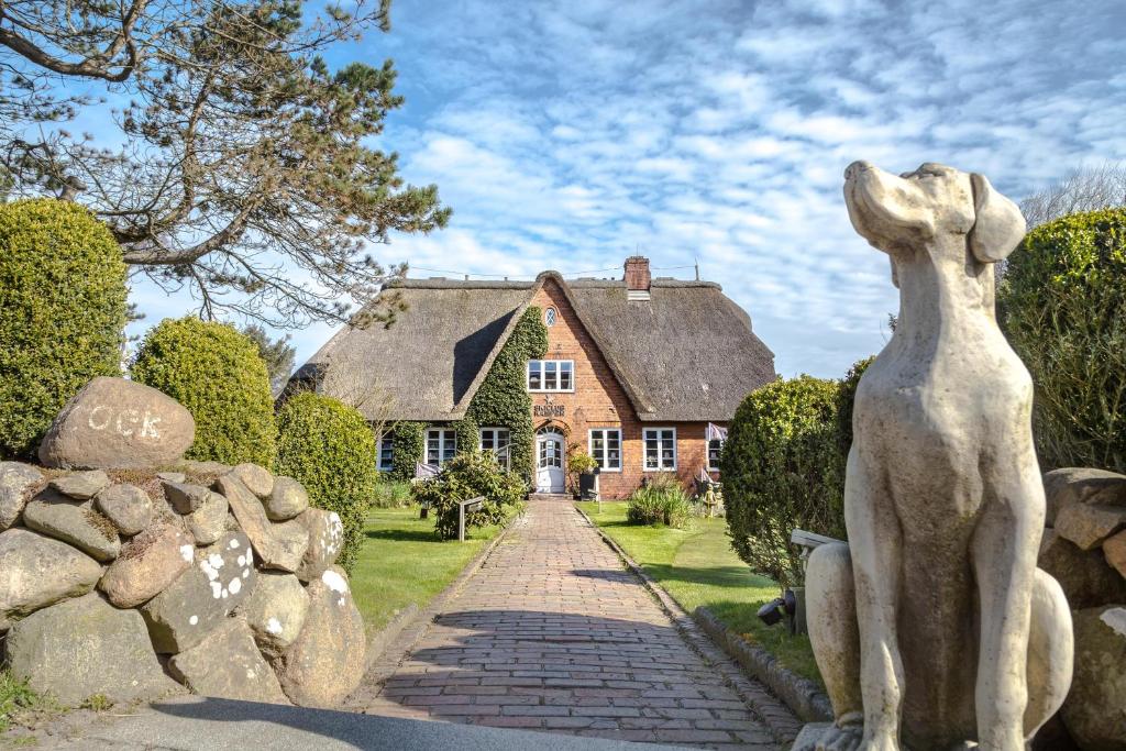 a statue of a woman in front of a house at Haus Peacock in Kampen