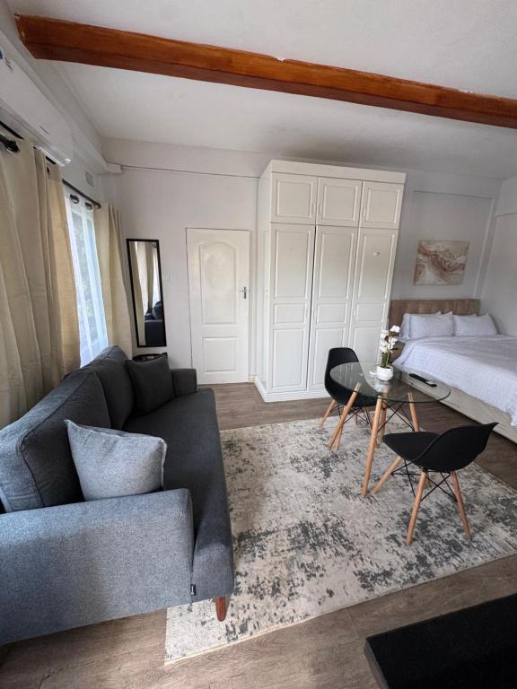 a living room with a couch and a bed at The Luxe Studio in Lusaka