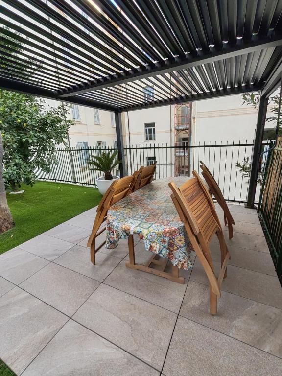 a table and chairs on a patio with a pergola at I Limoni in Sanremo