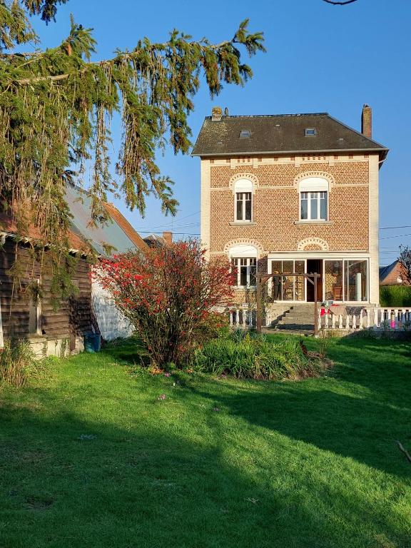 a large brick house on a green lawn at Cocorico in Boué