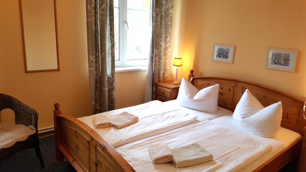 a bedroom with a bed with white sheets and pillows at Pension Am Holzgraben in Lübbenau