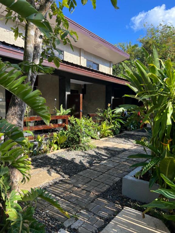 a house with a brick walkway in front of it at Hidden Garden Villa in El Nido