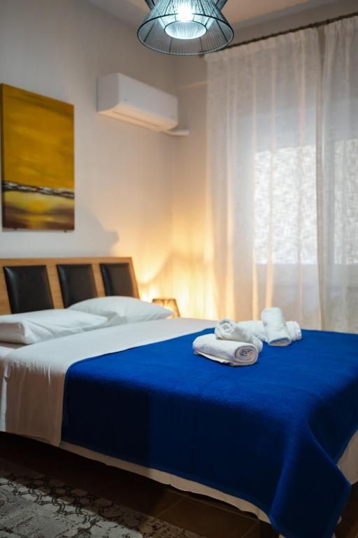 a bedroom with a blue bed with towels on it at The Hidden Cellar by Heavens Hall in Alexandroupoli