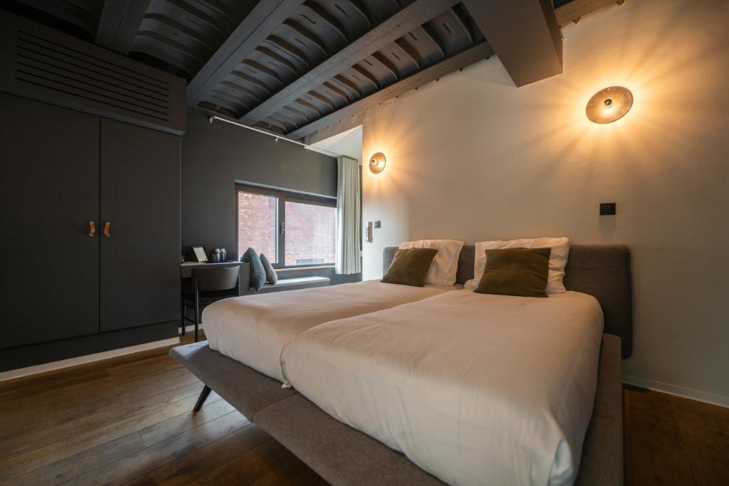 a bedroom with a large white bed with a window at K-Kanne in Kanne