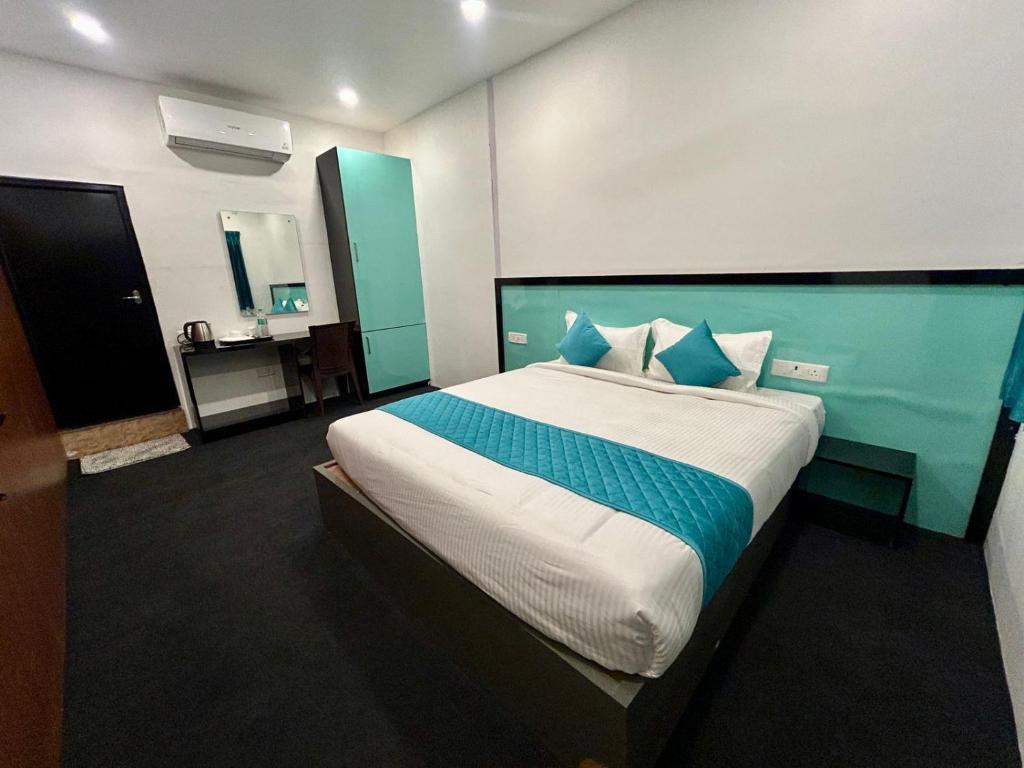 a bedroom with a large bed with blue and white sheets at Hotel unity Park in Pondicherry
