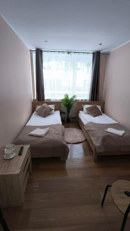 a bedroom with two beds and a large window at Leśna Przystań in Iława