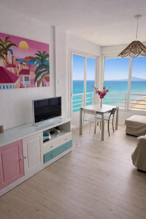 a living room with a television and a table with a dining room at Un Rincon en el Mar in Bellreguart