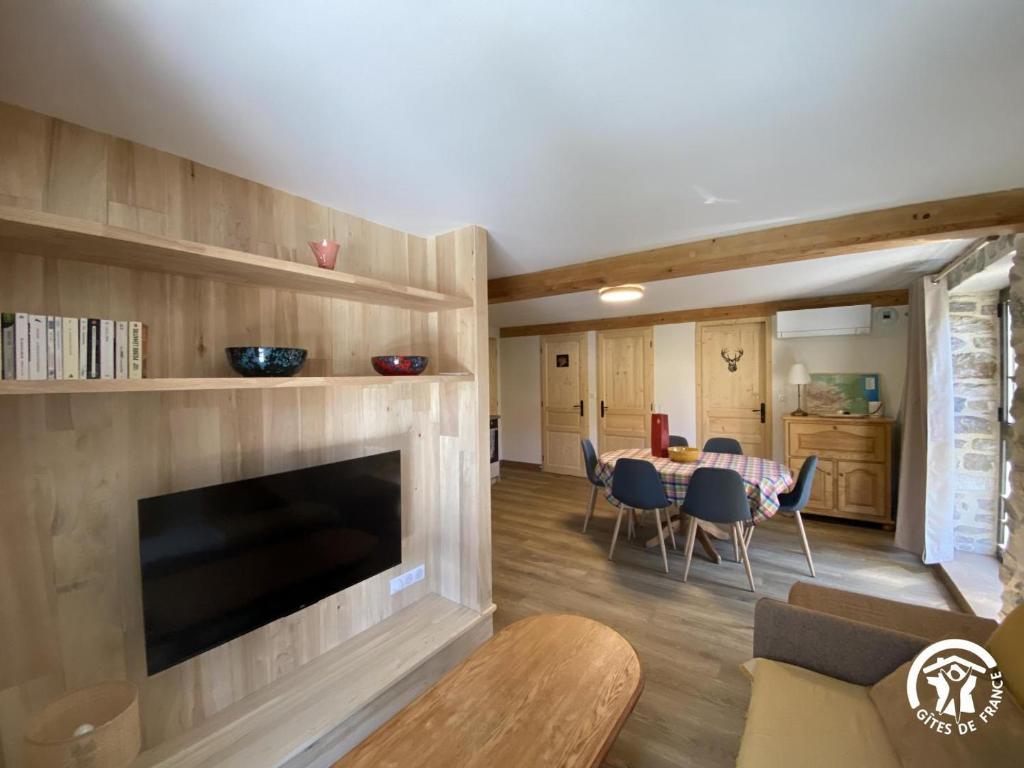 a living room with a fireplace and a table at Petit péric in Puyvalador