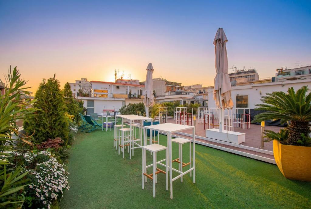 a group of tables and chairs on the roof of a building at NeapolitanTrips Hotel in Naples