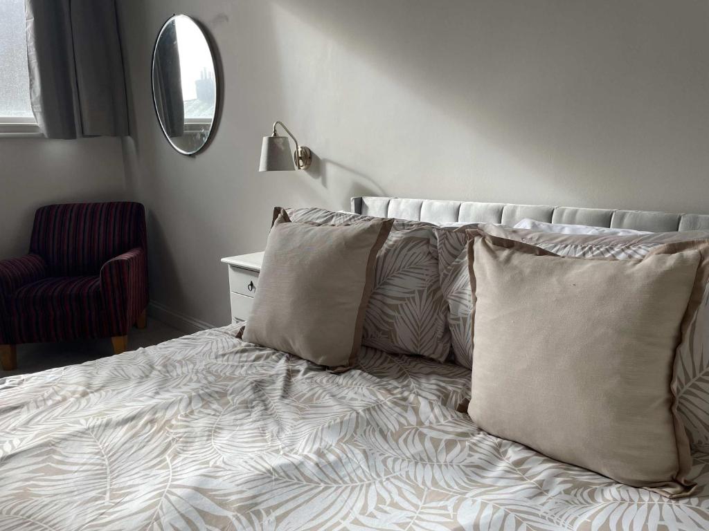 a bedroom with a bed with pillows and a mirror at Stillington Retreat in Stillington