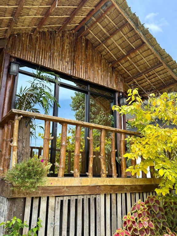 a balcony of a house with windows and plants at Thani's Little Cabin Rental - Native Room in Caibiran