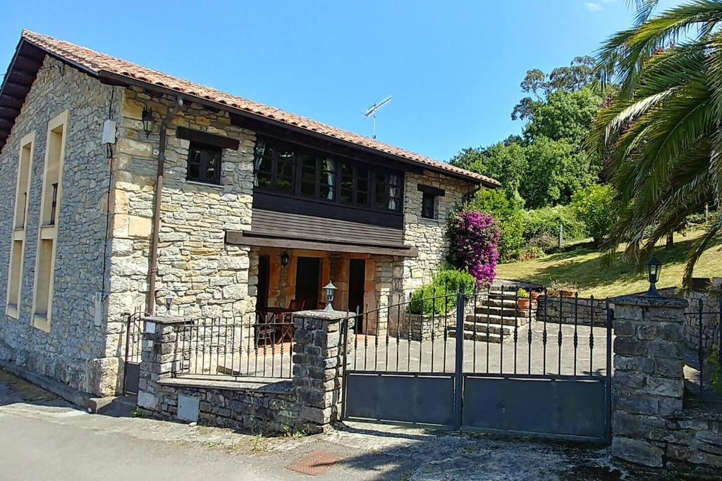 a stone house with a gate and a fence at El Verdecillo de Rodiles, Villaviciosa in Selorio