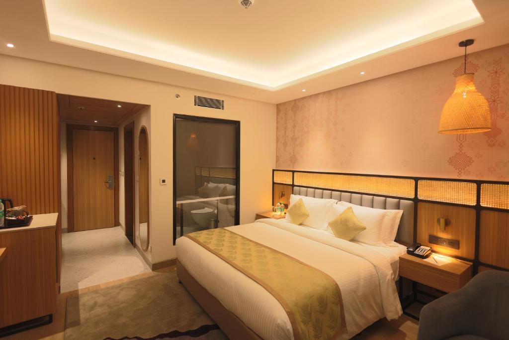 a hotel room with a bed and a bathroom at Hotel Palacio Paltan Bazaar in Guwahati