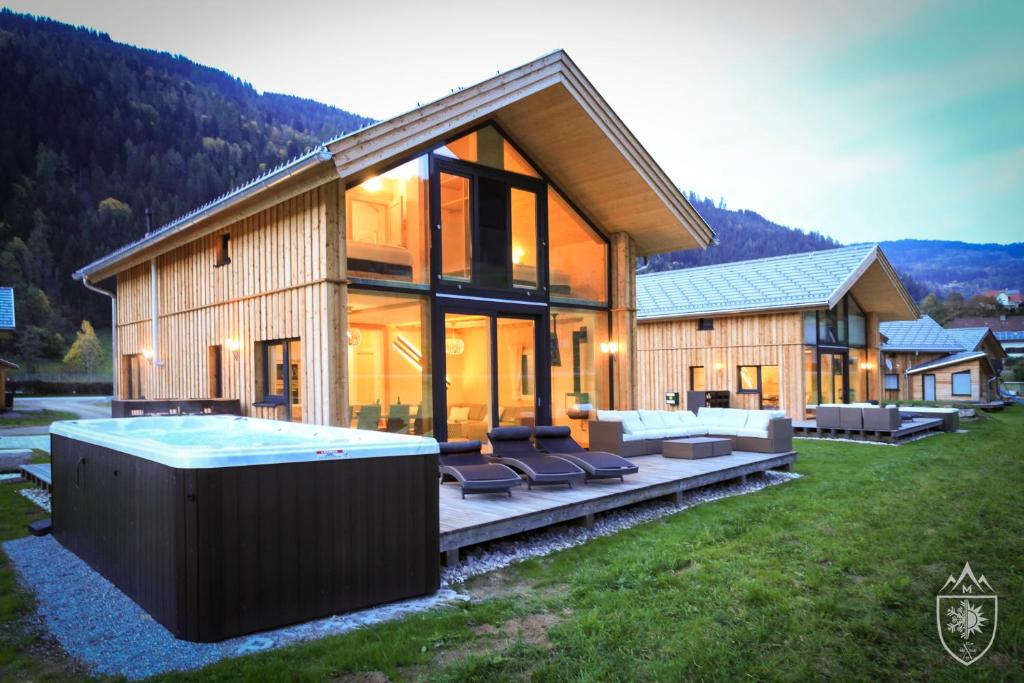 a large house with a hot tub in the yard at Feriendorf Murau by ALPS RESORTS in Murau